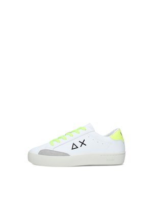 Sneaker bianca low-top con lacci e linguetta sul tallone giallo neon, dettaglio sulla punta in camoscio grigio e loghi geometrici neri sul lato.