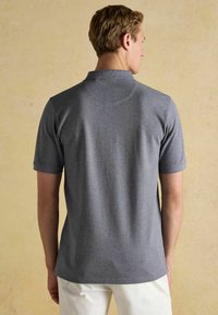 Sivá polo košeľa s krátkym rukávom, so stojatým golierom a hladkou textúrou, s jednoduchým dizajnom a rovným lemom.