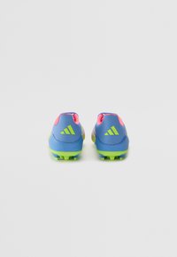 Blue soccer cleats with pink accents and green soles, featuring a textured upper and three striped logo on the heel.