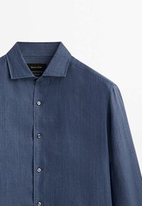Camicia button-up blu scuro con una texture liscia, colletto a media apertura e cinque bottoni rotondi, caratterizzata da un sottile motivo a righe.