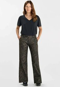 Zwart V-hals T-shirt gecombineerd met wijduitlopende broek met luipaardprint in donkere tinten, voorzien van zakken aan de voorkant en een losse pasvorm.