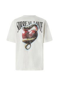 Bijela pamučna majica s grafičkim printom crvenog srca obavijenog zmijom, s natpisom "SURREAL LOVE", kratki rukavi.
