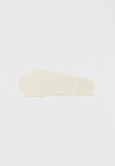 Clear plastic sandal with a smooth, flat sole. Features a minimalist design and light yellow color. Textured bottom for grip.