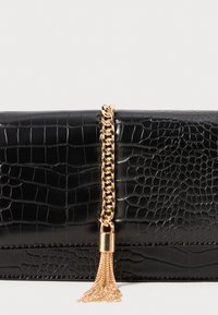 Črna torbica s krokodilskim vzorcem in zlatim verižnim naglasi ter zlatim detajlom s klinom. Gladka tekstura s togim oblikovanjem.
