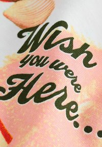 Baumwollstoff mit einer weichen, strukturierten Oberfläche, auf der in grüner Schrift der Text "Wish you were Here..." auf einem rosa, illustrierten Hintergrund zu sehen ist.