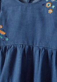 Džínové šaty s okrúhlym výstrihom, nariaseným pásom a pestrofarebnou kvetinovou výšivkou v oranžovej a zelenej farbe na hornej ľavej strane.