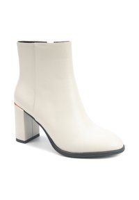 Botine din piele sintetică albă până la gleznă, cu vârf ascuțit, toc bloc, talpă neagră și design minimalist. Accent auriu subtil la baza tocului.