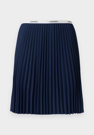 Jupe plissée navy avec un design texturé, taille élastique ornée du logo "LACOSTE" et tissu lisse.