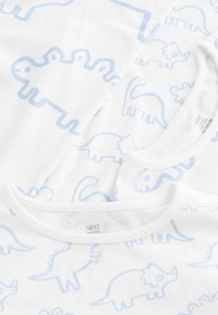 T-shirts en coton blanc avec des imprimés de dinosaures bleu clair. Col rond, texture douce, présentant différentes formes et designs de dinosaures.
