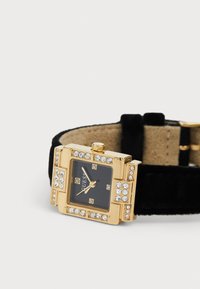 Vierkant zwart uurwerk met goudkleurig frame, versierd met heldere kristallen, in combinatie met een zwarte fluwelen band.