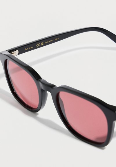 Černé plastové sluneční brýle s velkými obroučkami a růžově tónovanými čočkami, s detailem zlatého loga na vnitřní straně nožiček, vyrobené v Itálii.