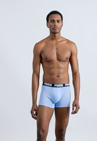 Svetlomodré boxerky z hladkej tkaniny, so čiernym pásom s logom "PUMA", priliehavý strih a bez viditeľných vzorov.