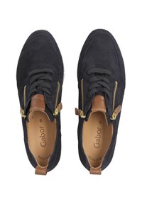 Zapatillas de ante azul marino con detalles de cuero marrón, cremalleras doradas y cordones negros. Presenta una puntera redondeada y una plantilla acolchada.