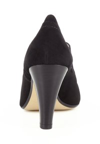 Chaussure à talon haut en daim noir avec un bout pointu et un talon conique. Présente une texture lisse et un détail de couture minimal sur la tige.