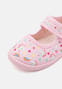 Rosa stoff sko med flat såle, med et design av enhjørninger og regnbuer pyntet med fargerike hjerter. Dobbelt stropp lukking for sikker passform.