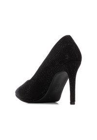 Zapato de tacón alto negro con una superficie texturizada que presenta pequeños rhinestones, punta afilada y un tacón de aguja delgado, mostrando un perfil elegante.