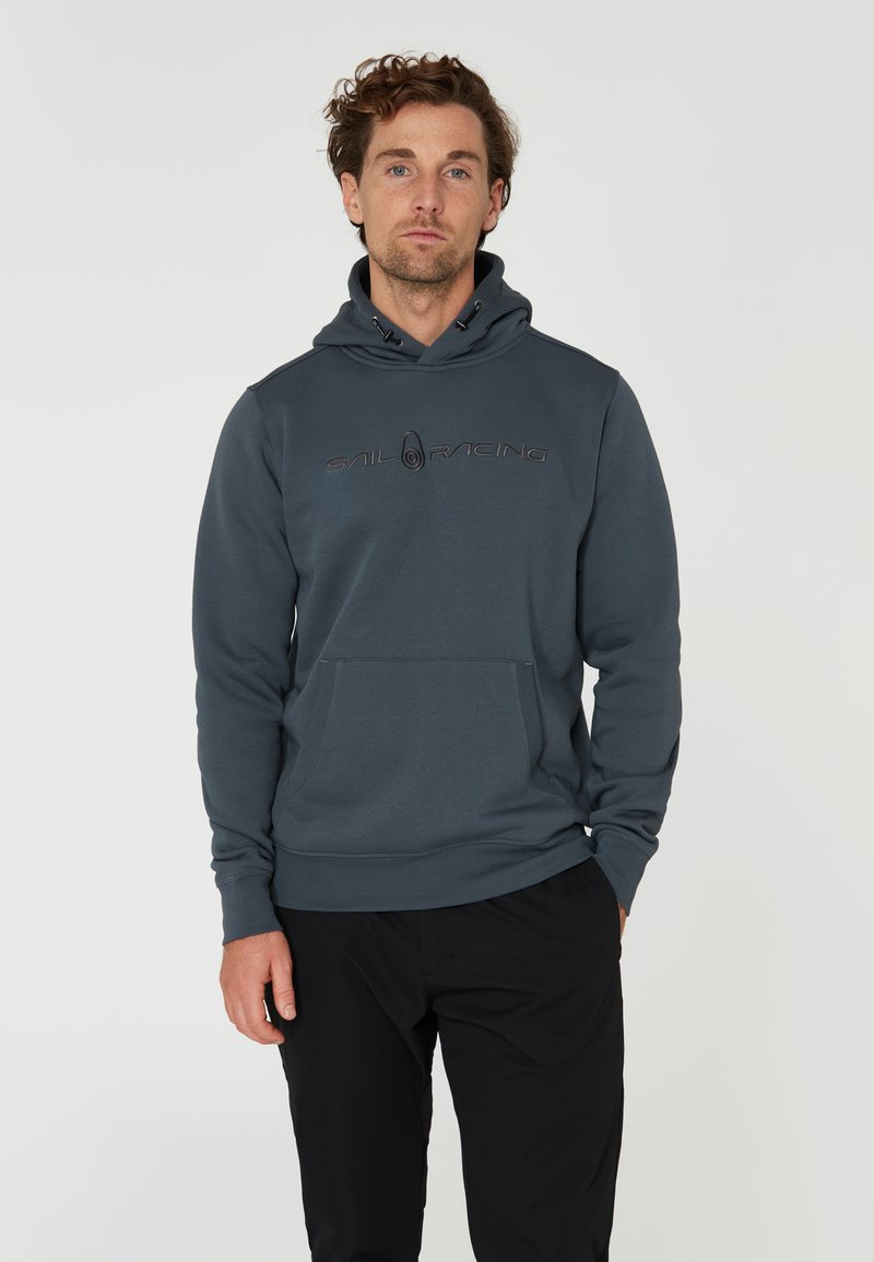 Mörkblå huvtröja i mjukt tyg, med en framficka och dragsko till huvudet. "SAIL RACING"-logotypen är tydligt synlig i svart.