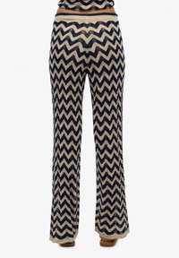 Donkerblauwe en beige zigzagpatroon flared broeken met een gebreide textuur, voorzien van een brede tailleband en een losse pasvorm door de benen.