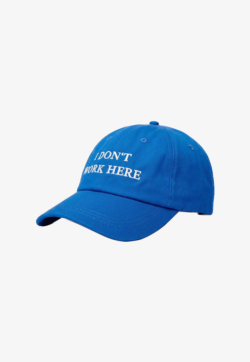 Casquette de baseball bleue avec visière courbée et texte brodé en blanc "I DON'T WORK HERE" sur le panneau avant.