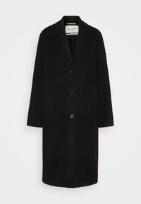 Manteau long en laine noire avec revers crantés, trois boutons à l'avant et poches latérales, présenté sur fond blanc.