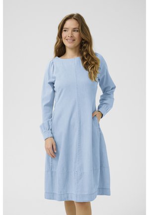 Svetlo modra denim obleka z dolgimi rokavi, okroglim izrezom in stranskimi žepi. Ima ohlapen kroj in zbrane manšete rokavov.