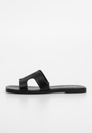 Black slide sandal with a smooth leather upper, open-toe design, and flat sole. Features a double strap with a cutout design for ventilation.
