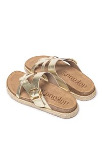 Goldene metallische Sandalen mit gekreuzten Riemen, ausgestattet mit einer Schnalle, einer gepolsterten braunen Innensohle und einer geflochtenen, mit Jute umwickelten Außensohle.