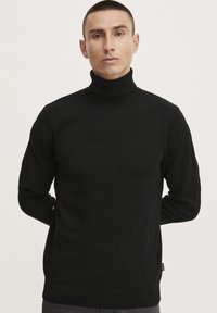 Schwarzer Rollkragensweater mit strukturierten horizontalen Streifen, gerippten Bündchen und Saum. Hergestellt aus einem weichen, elastischen Material mit figurbetonter Passform.