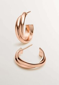 Pendientes de aro en oro rosa con un diseño liso y retorcido. La superficie es brillante, con una textura suave y un cierre de poste sencillo.