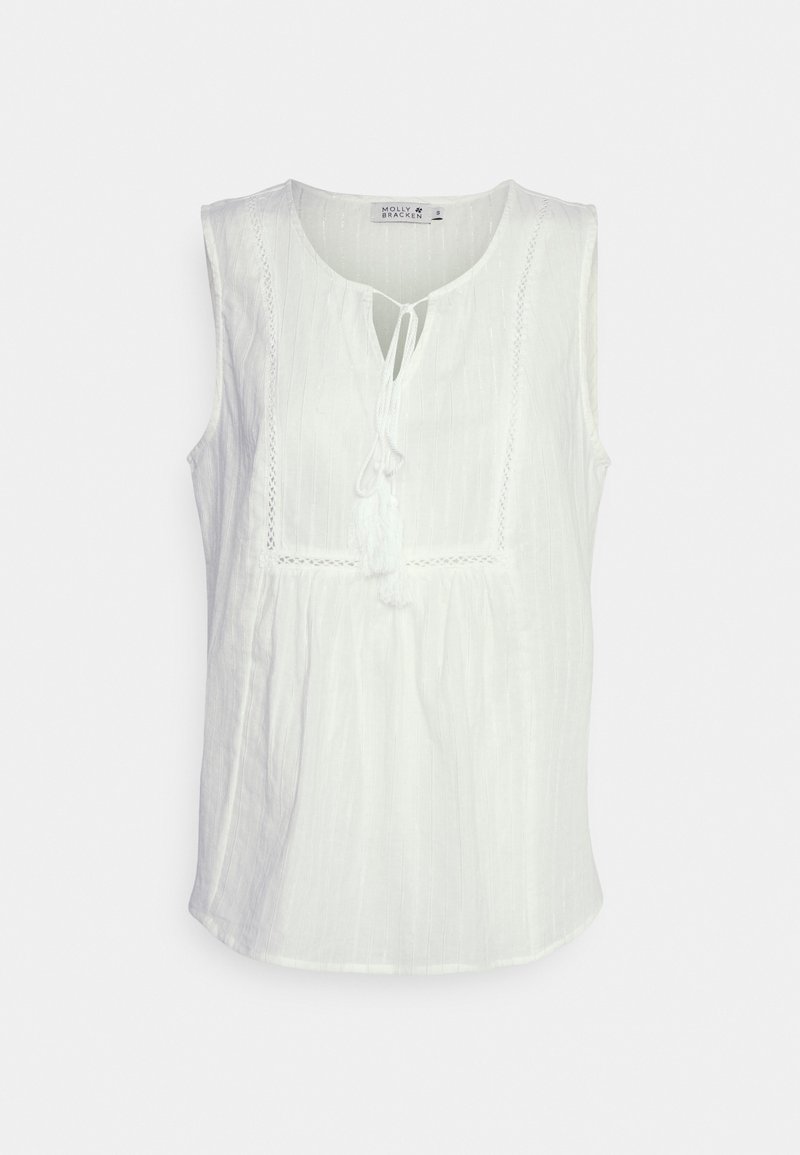 Blouse blanche sans manches en tissu texturé avec un col rond et un détail noué, présentant un panneau délicatement brodé sur le devant.