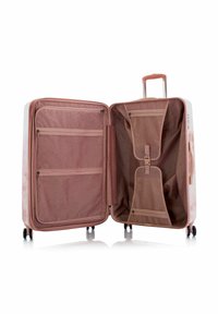 Hartschalenkoffer in Weiß und Pink mit strukturiertem Innenraum. Verfügt über mehrere zipbare Fächer und einen ausziehbaren Griff. Vier Räder.