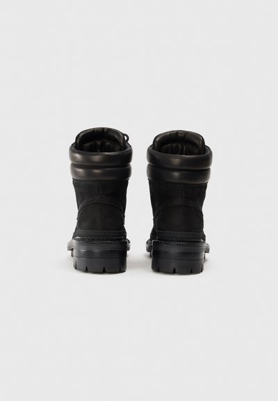 Bottines noires avec un design en daim, des accents en cuir texturé, un bord rembourré et une semelle extérieure en caoutchouc robuste avec un motif de traction.