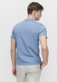 Ljusblå kortärmad polo-shirt, tillverkad av ett slätt tyg, med en ribbad krage och en ren, minimalistisk design utan utsmyckningar.