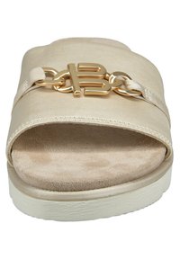 Beige slide-sandal med en mjuk mockaliknande fotsula, släta tygovandelar och en framträdande guldkedjeaccent på remmen. Texturerad sula.