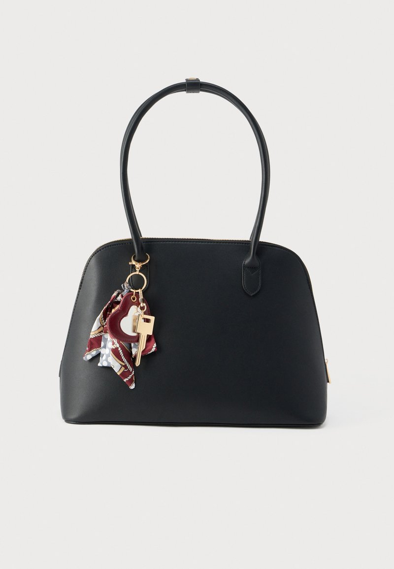 Sac à main en cuir noir de forme arrondie, équipé d'un porte-clés en métal doré et d'un foulard multicolore en accent. Texture lisse, fermeture à glissière.