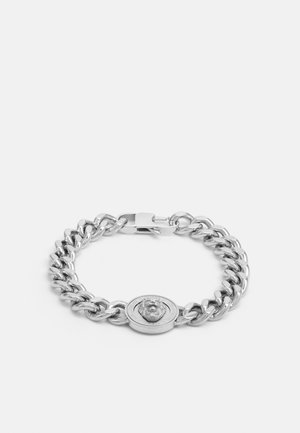 Bracelet chaîne en argent avec des maillons épais et un médaillon rond ornée d'une tête de lion en relief et d'un texte gravé sur le pourtour.