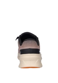 Scarpa da corsa in morbido materiale tricot rosa chiaro con un tallone nero, intersuola bianca, suola testurizzata e una linguetta per un facile indossamento.