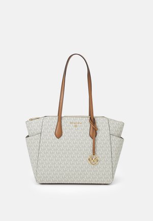 Sac fourre-tout beige en tissu à motifs avec le logo "MK". Poignées et accents en cuir marron. Fermeture zippée et poches latérales visibles.