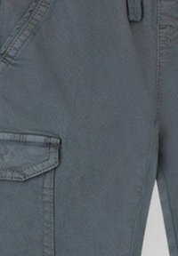 Pantalones cargo grises con múltiples bolsillos, una textura suave y detalles de costura en contraste, diseñados para la utilidad y la comodidad.