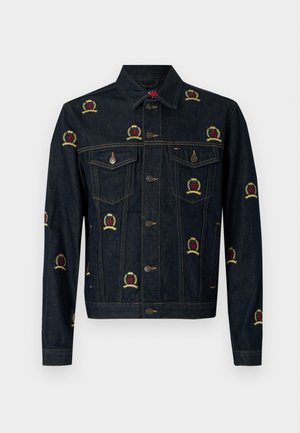 Sötétkék farmerdzseki piros és sárga hímzett címermintákkal. Két mellzsebbel és ezüstszínű szerelvényekkel rendelkezik. Klasszikus szabású.