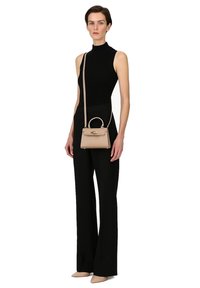 Borsa a mano in pelle beige con manico superiore e tracolla rimovibile. Texture liscia, forma rettangolare e accenti in hardware dorato.