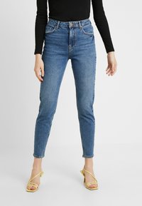 Blå denimhögmidjade jeans med smal passform, med knappstängning, framfickor och subtila slitningar.