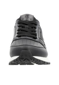Black athletic shoe with a textured leather upper, lace closure, contrasting white midsole, and a patterned tread outsole for traction.