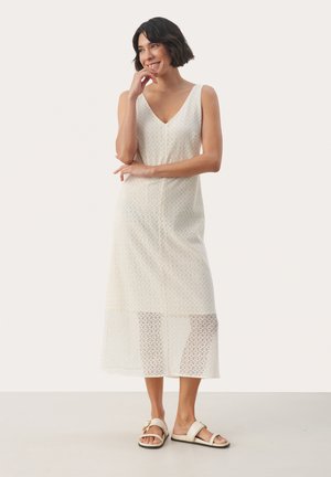 Hvid blonde midilængde kjole med V-hals, med et blomstermønster. Sammen med lyse sandaler for et lagdelt tekstureret look.