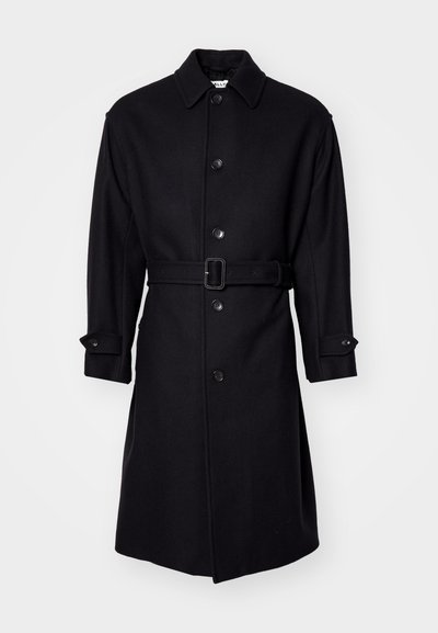 Černý vlněný kabát s límcem, zapínáním na knoflíky a pásem. Má dlouhé rukávy s manžetami na knoflíky a rovný, po kolena sahající střih.