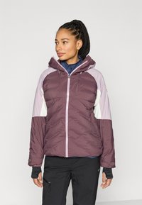 Odejana jakna v odtenkih vijolične barve, z ruto in kontrastnimi svetlo vijoličnimi in belimi paneli. Ima sprednjo zadrgo in šiviljske podrobnosti.