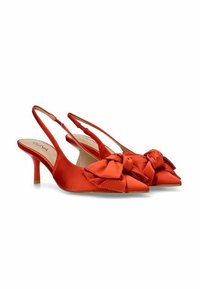 Tacones slingback de satén rojo con punta afilada y acentos de lazo. Presenta un tacón delgado y una textura suave y brillante. Etiqueta de la marca visible en el interior.