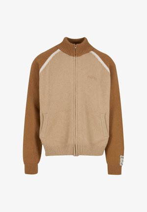 Gebreide ritssluitingtrui in bruin en beige, met een hoge kraag, zijzakken en een gestructureerde afwerking met een witte accent op de schouders.