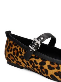 Ballerine con stampa leopardata in pelliccia sintetica, dotate di una cinghia in pelle nera e dettaglio con fibbia argentata. Suola nera a profilo basso.