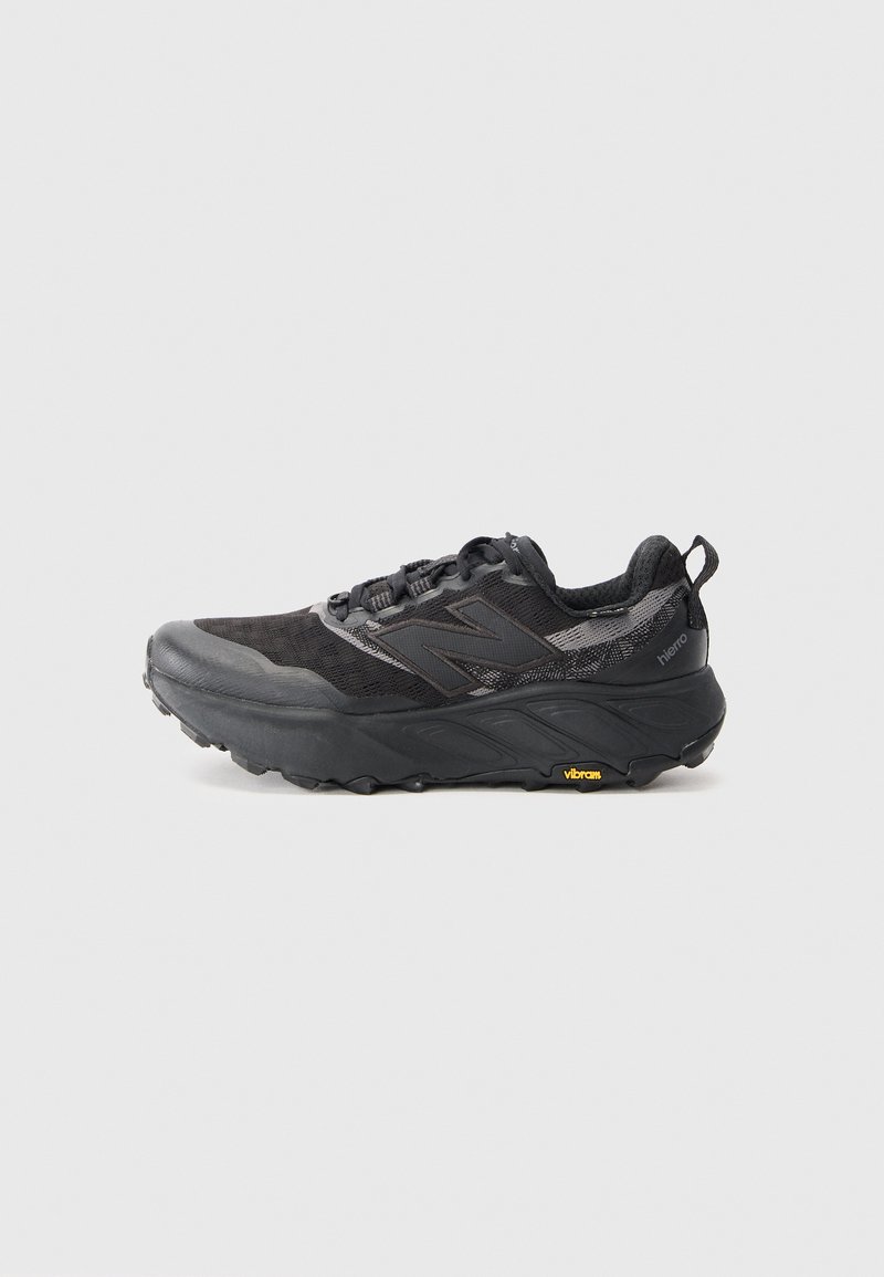 Trail running shoe in black with textured upper and synthetic material. Features a Vibram outsole and reinforced toe cap. Light cushioning visible.
